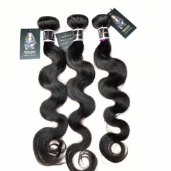 Three bodywave human hair bundles in 22, 22 and 20 inches laid flat showing wave pattern